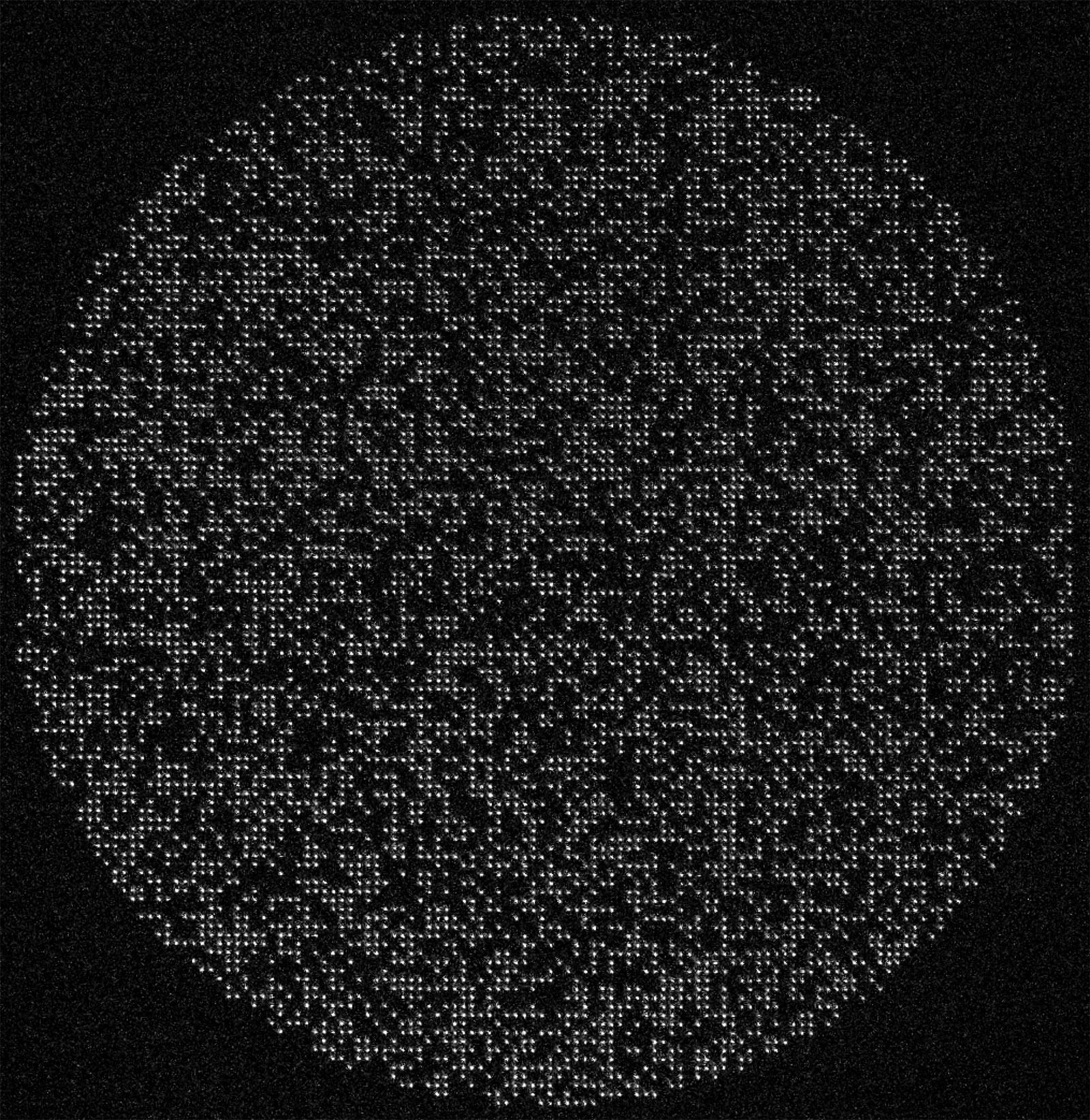 6,100 cesium atoms held by optical tweezers. The full circular array is approximately one millimeter wide.