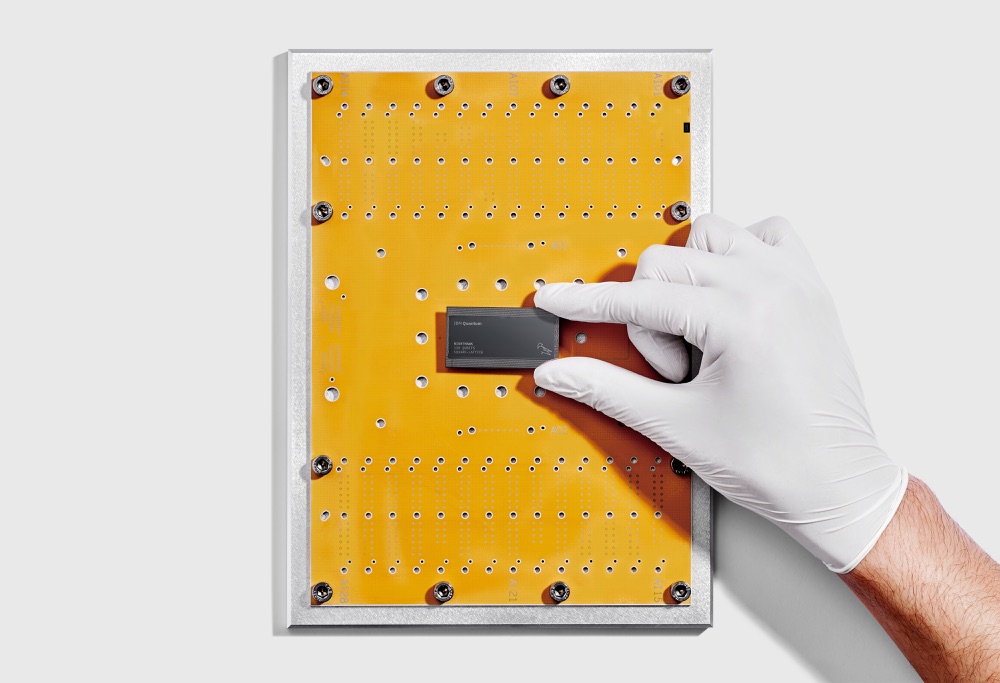 IBM researcher holding a Nighthawk quantum chip, photographed in 2025